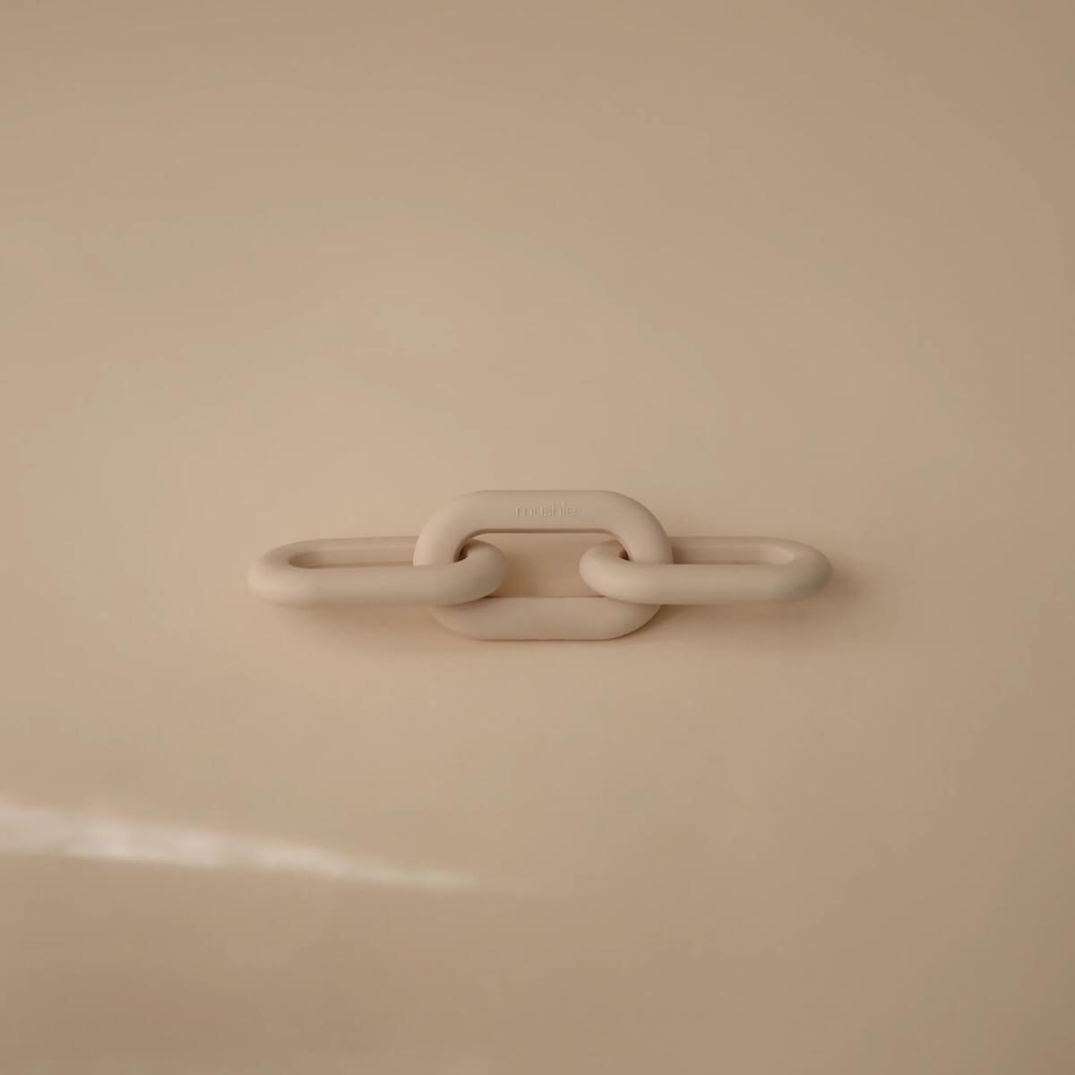 Jouet de dentition en silicone Mushie links shifting Sand 20x5cm